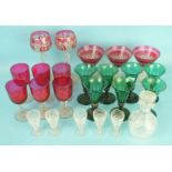 A set of six green glass wine glasses, the faceted bowls on knopped stems and plain circular feet,