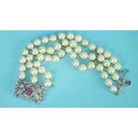 A three-strand pearl bracelet of forty-eight cultured pearls to a pierced white metal clasp set