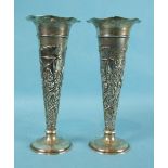 A pair of Edwardian spill vases with embossed decoration of reeds and flowers, on loaded bases, 21cm