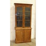 A Victorian burr walnut bookcase, the moulded cornice above a pair of plain glazed doors and a