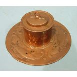 A Newlyn copper inkwell of cylindrical form, with lid, on a circular base with embossed fish