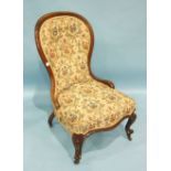 A Victorian rosewood spoon-back nursing chair with serpentine seat and button back, on carved