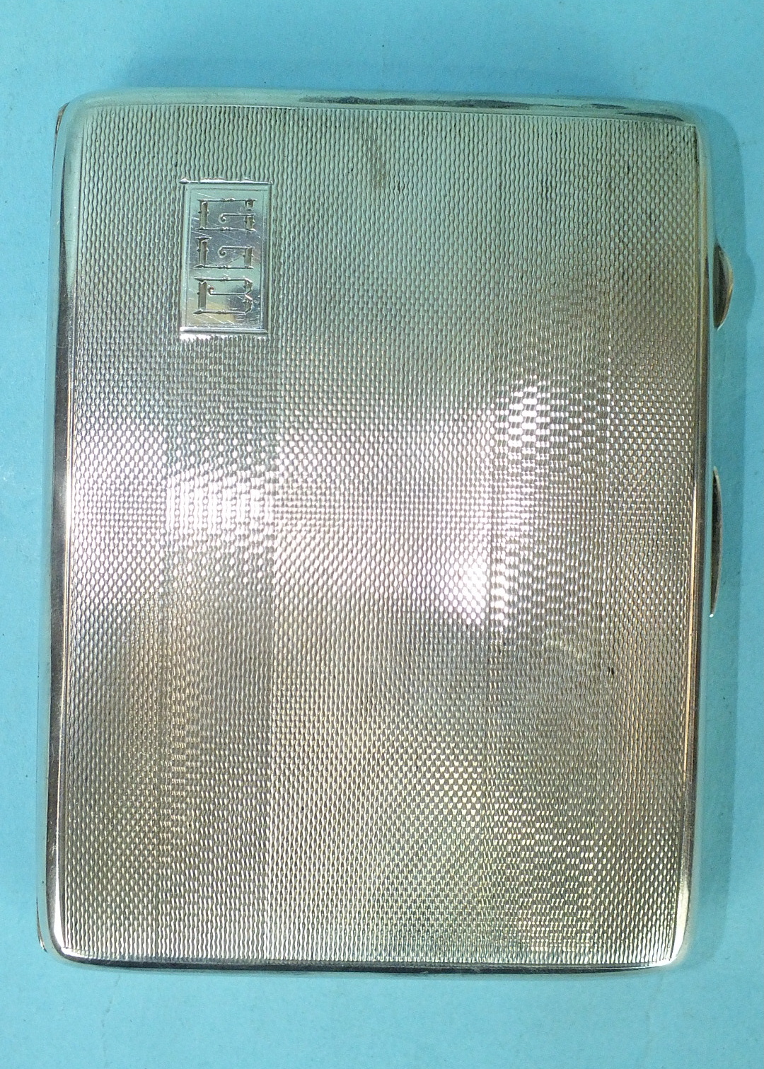 An engine-turned silver cigarette case, Birmingham 1946, 11 x 8.5cm, engraved initials outside,