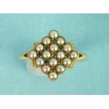 An Edwardian pearl and demantoid garnet cluster ring set a square cluster of sixteen pearls with