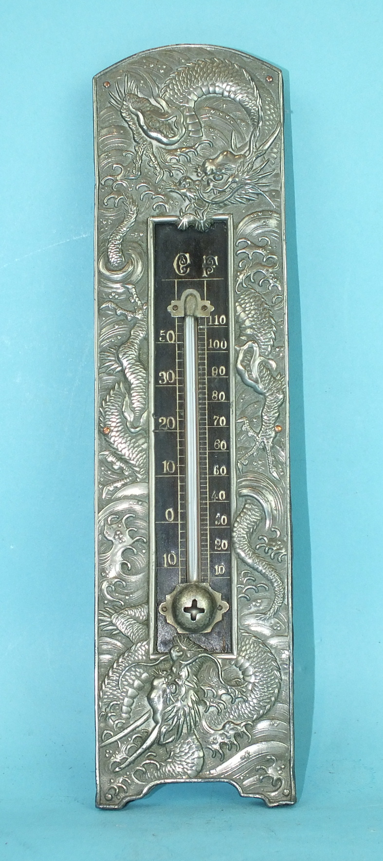 An early-20th century Chinese thermometer within a white metal frame embossed with dragons, 23cm