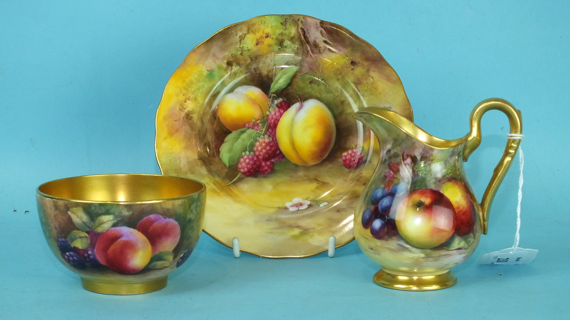 A Royal Worcester porcelain sugar bowl painted with fruit by George Mosely, gilt interior, a similar