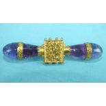 A Victorian brooch of two amethyst tear-drop-shaped batons set horizontally either side of a