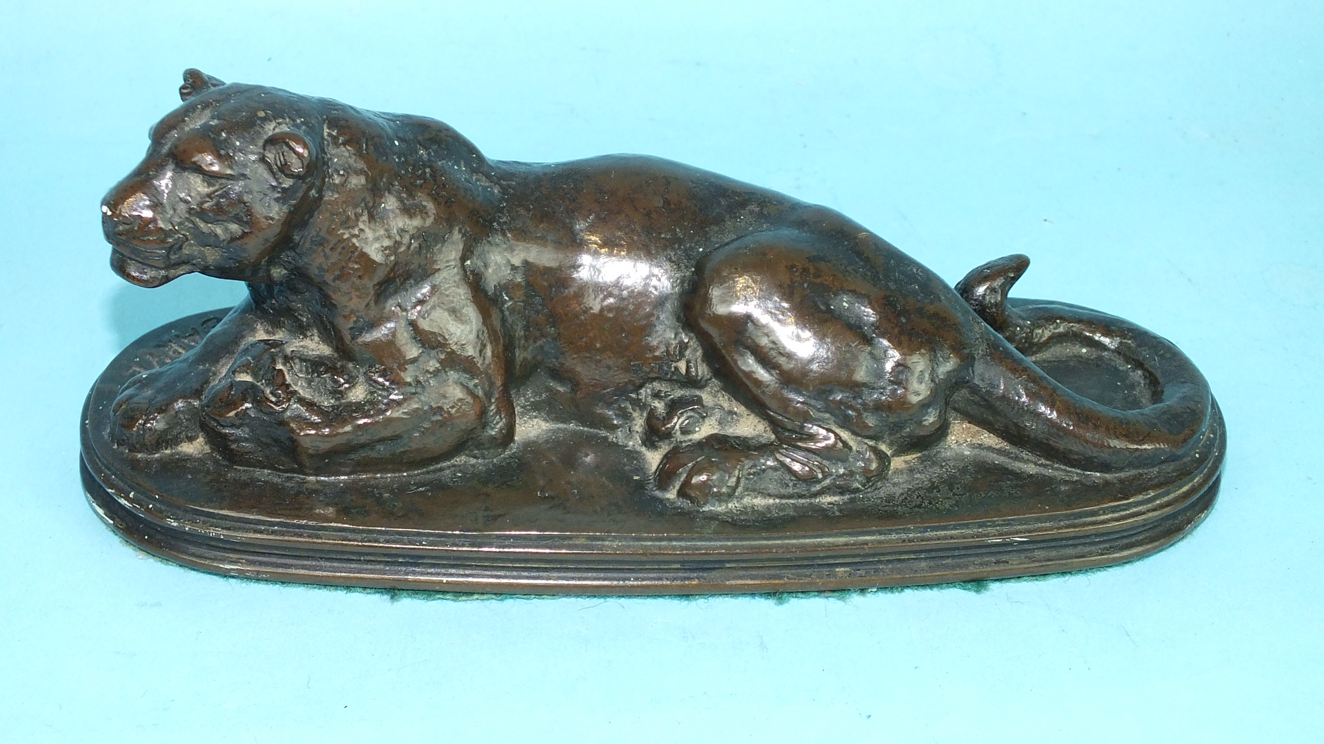 After Antoine-Louis Barye, a bronze study of a lioness lying down, on shallow reeded-edge plinth,