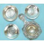 A Continental white metal tea strainer with pierced foliate border and handle, 14cm long and three