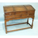 An antique oak fall-front clerk's desk enclosing a fitted interior, on turned legs joined by