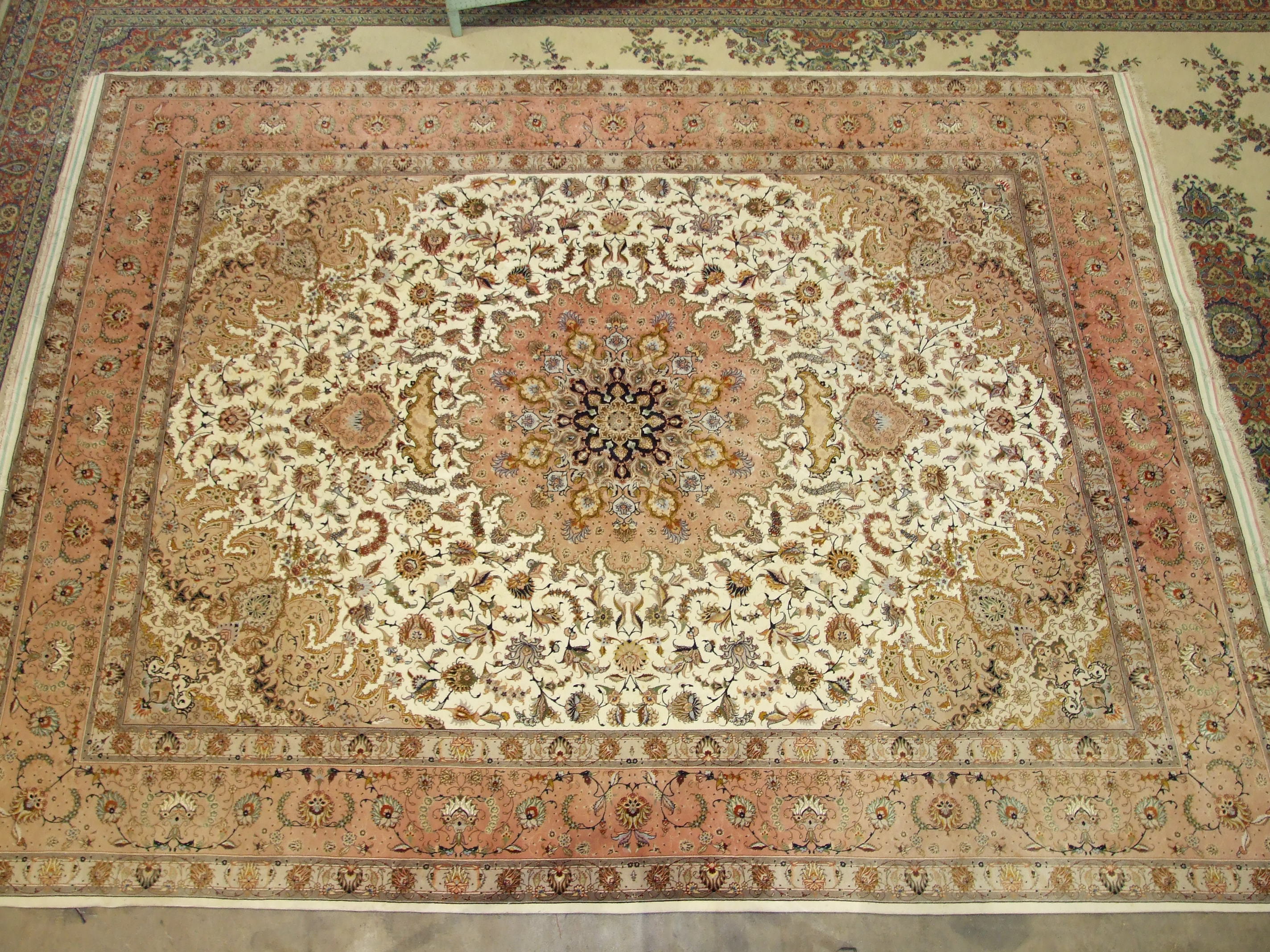 A modern Tabriz pattern 'medallion' design wool carpet, the design on ivory and salmon pink