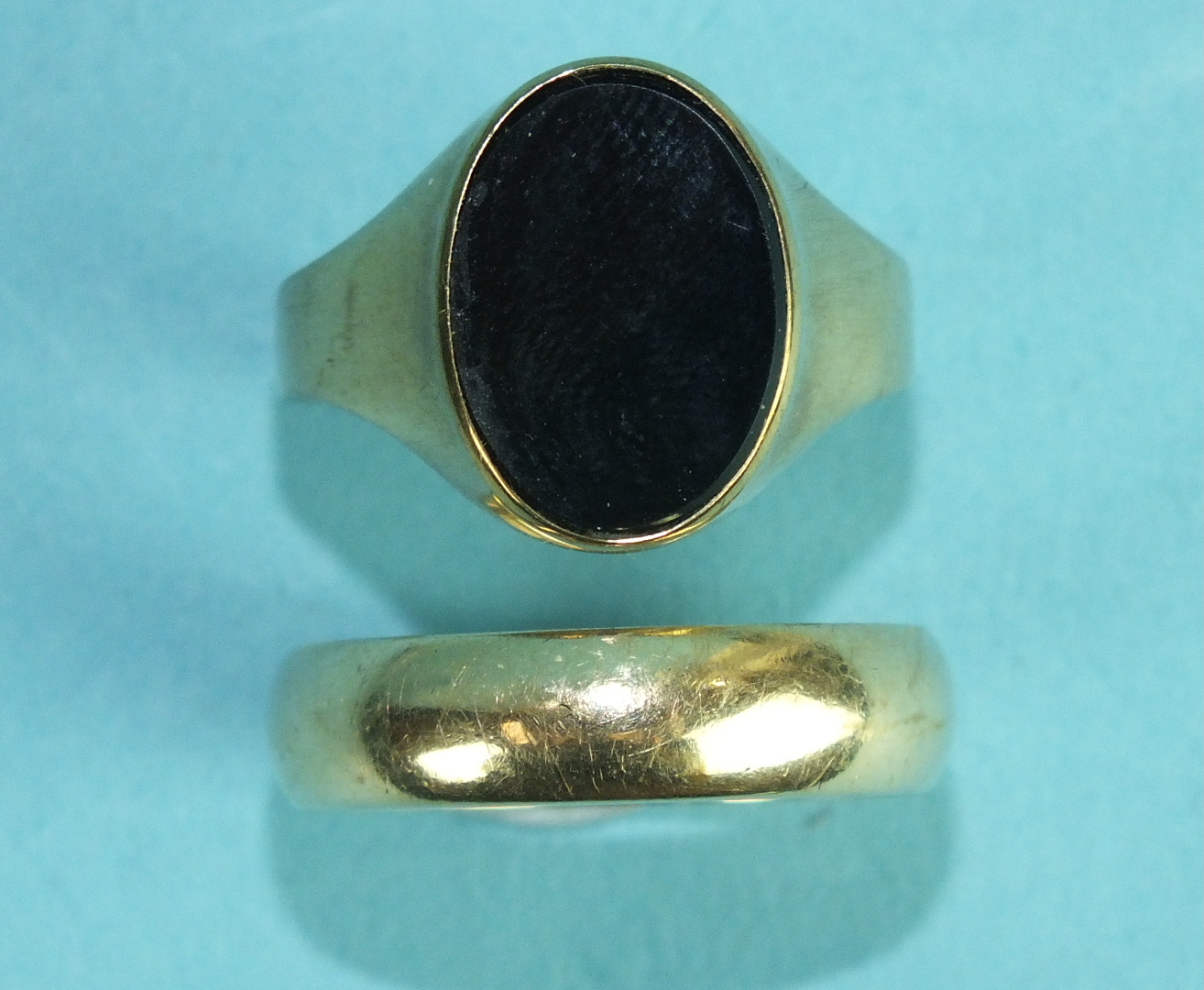 A 9ct gold wedding band, size X, 5.3g and a 9ct gold signet ring set onyx, size W, 3.1g, (2).