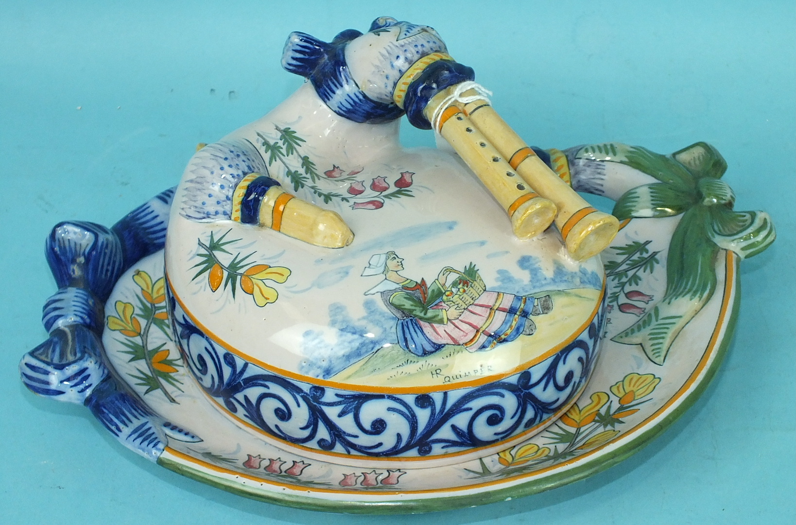 A Quimper pottery covered dish formed from Breton pipes, decorated with flowers, the cover with a