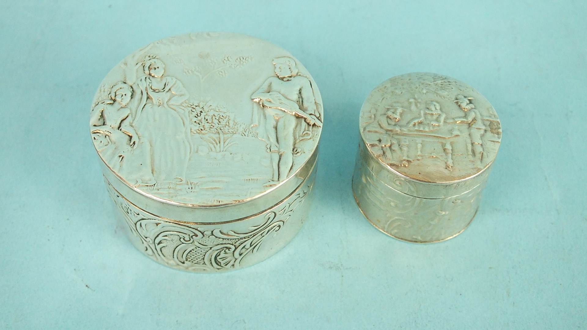 A small Continental silver round snuff box, the lid embossed with a musician and two girls, 4.8cm - Image 2 of 2