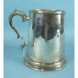 A silver tankard of plain form with scroll handle, 12.5cm high, Sheffield 1940, dent to base,