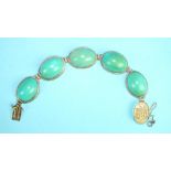 A Chinese bracelet of five large oval turquoise cabochons, each 2.5 x 1.8 x 0.9cm, in marked 14k