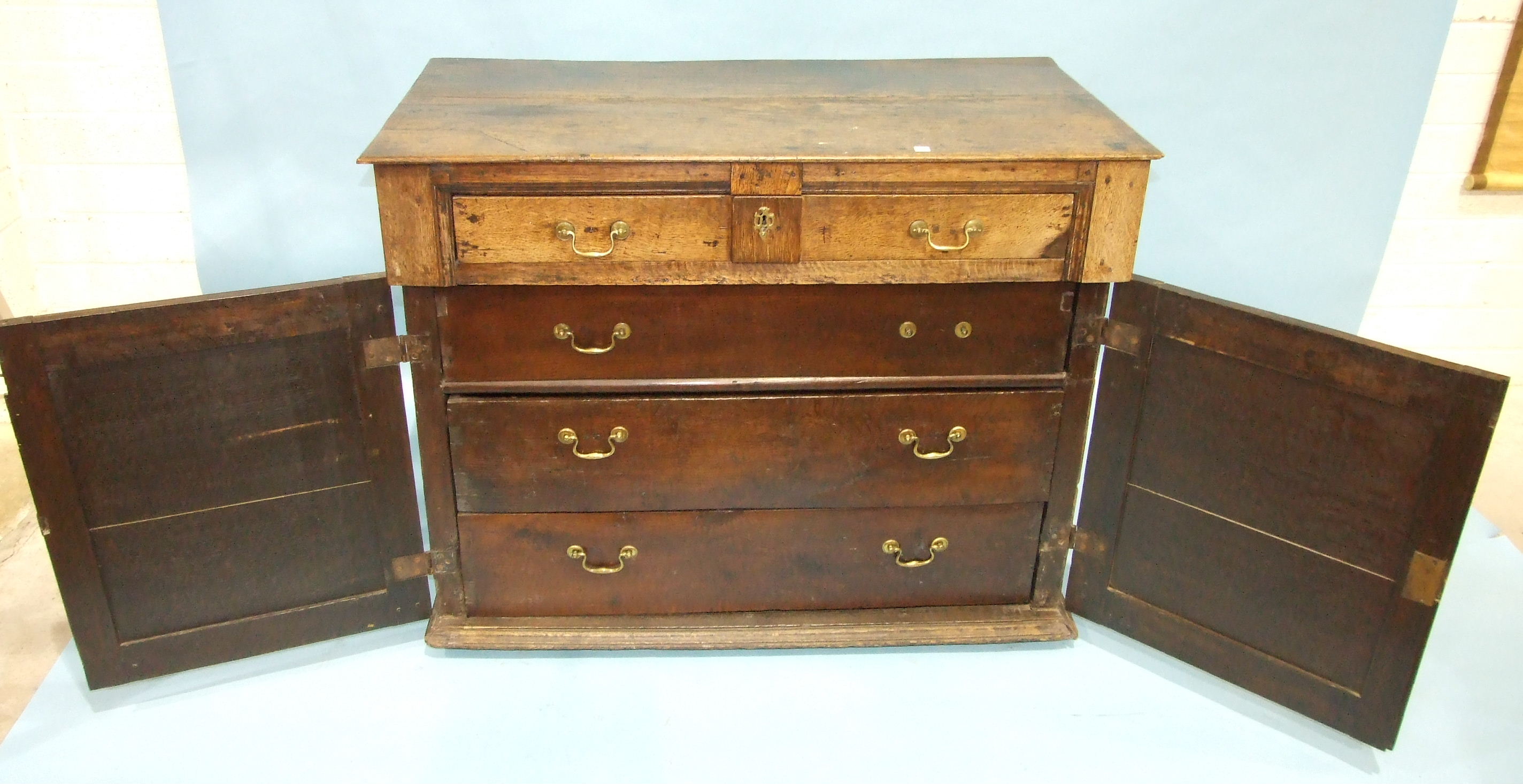 An antique oak chest having a frieze drawer above a pair of panelled doors, enclosing three - Image 2 of 2