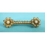 A Victorian bar brooch, each terminal set with a coral and seed pearl-set daisy cluster, unmarked,