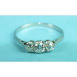 A three-stone diamond ring, the old brilliant-cut diamonds claw set in white metal mount, size O,