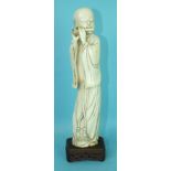 A 19th century Chinese ivory figure of a man in long robes, playing a flute, standing on a finely-