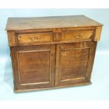 An antique oak chest having a frieze drawer above a pair of panelled doors, enclosing three