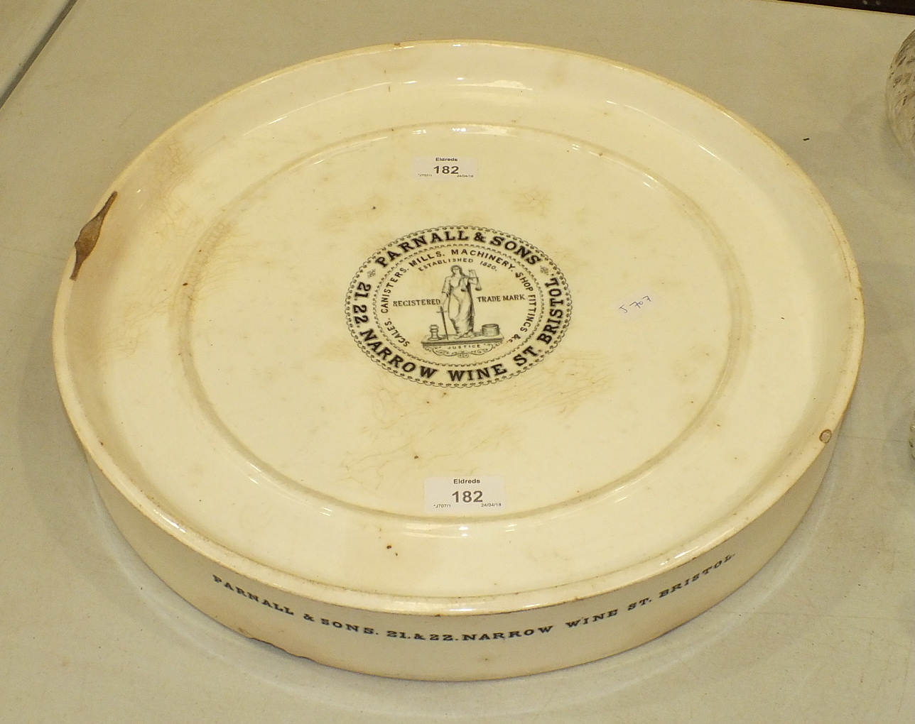 A Wedgwood ceramic circular stand with central advertising transfer print 'Parnall & Sons, 21, 22