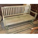 A teak garden rocking bench with foot rest, 150cm long.