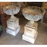 A pair of cast concrete garden urns on plinths, 50cm diameter, 82cm high, (2).