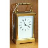 A brass case carriage timepiece with carrying handle, 14cm high.