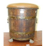 An oak and brass coopered log bin/stool, with metal liner, padded seat and lion mask ring handles,