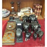 A collection of ebony elephant figures, a brass decorated extending wooden book rack and other