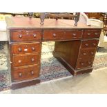 An Edwardian stained wood kneehole desk, the rectangular top with writing inset above three frieze