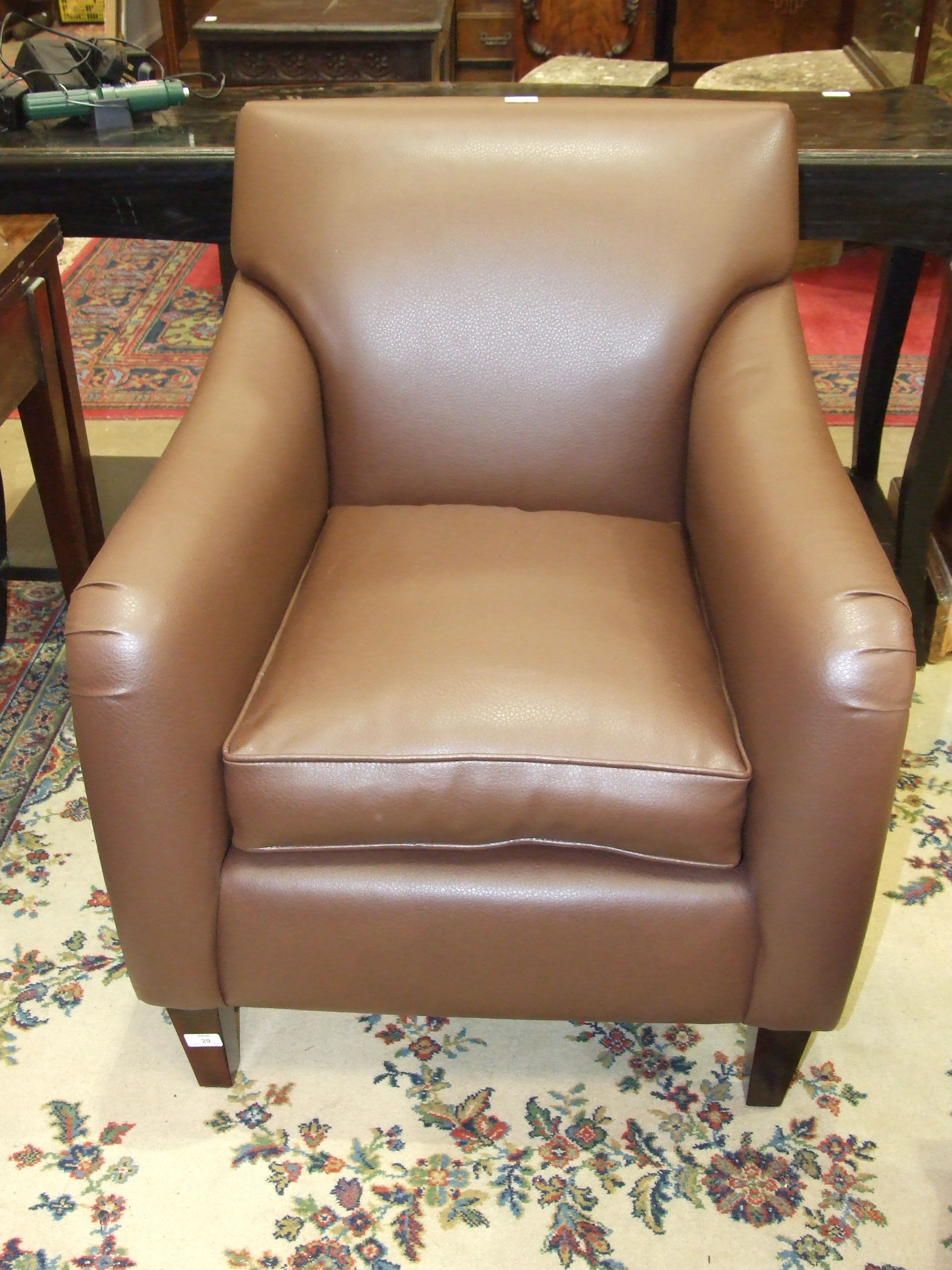 A modern leatherette armchair with loose cushion.