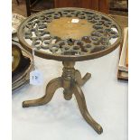 A late-19th century brass trivet with pierced circular top, on triform support.