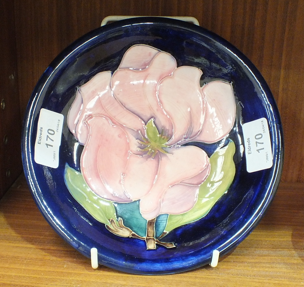 A Moorcroft shallow bowl with tubeline decoration of a magnolia flower on a blue ground, 18.5cm