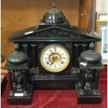 A late-19th century black slate striking mantel clock garniture, the case with domed portico and