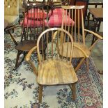 An Ercol light wood spindle-back armchair, one other and a dark wood rocking chair, (3).