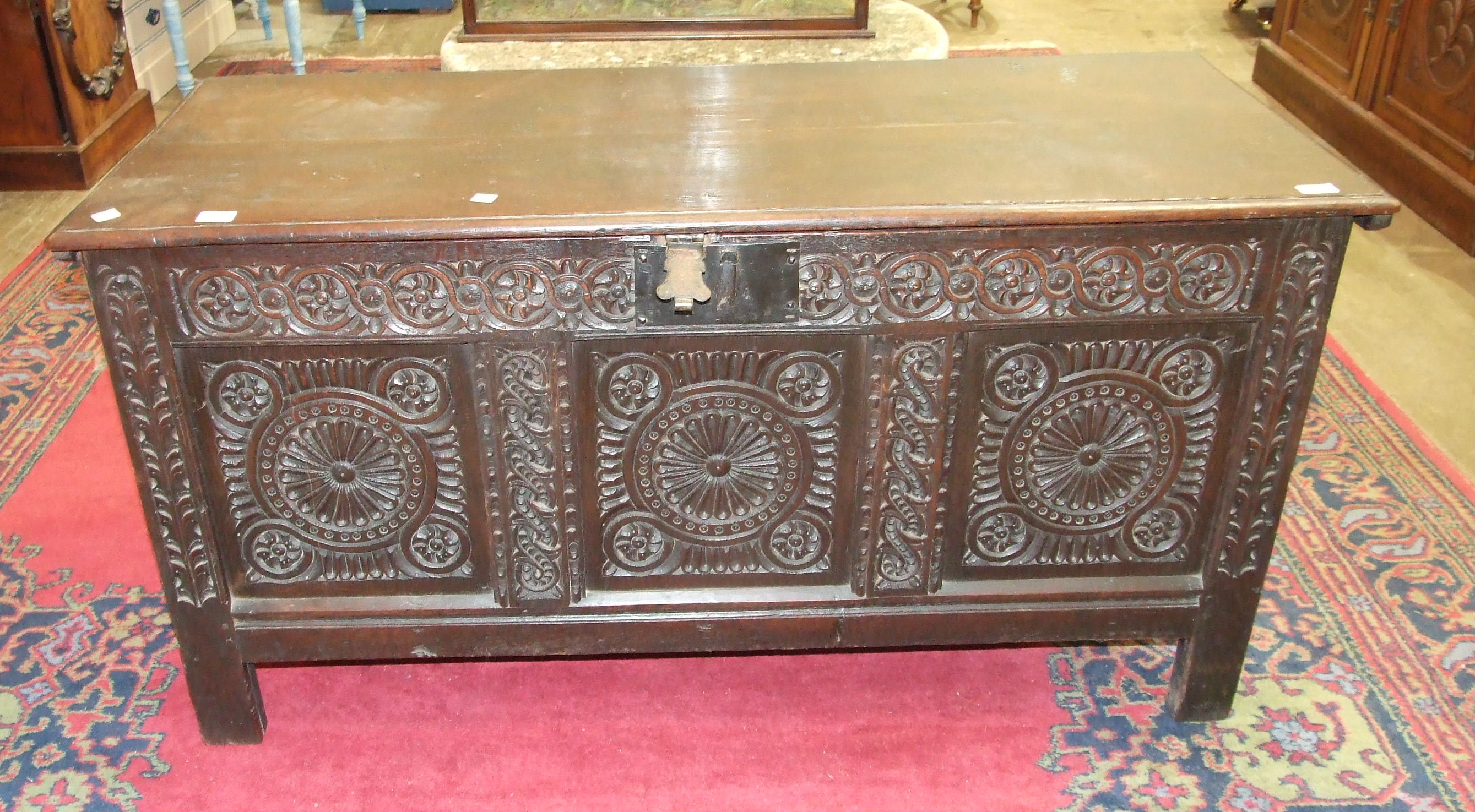 An antique oak coffer with carved panel front, 140cm wide.