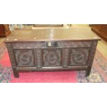 An antique oak coffer with carved panel front, 140cm wide.