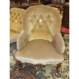 A Late-Victorian walnut upholstered button-back salon chair on carved cabriole front legs.