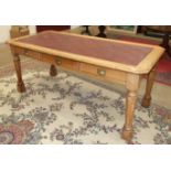 A Late-Victorian oak library table, the top inset with writing surface above three drawers, on