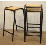 Nine painted tubular frame laboratory stacking stools with varnished plywood seats, (9).