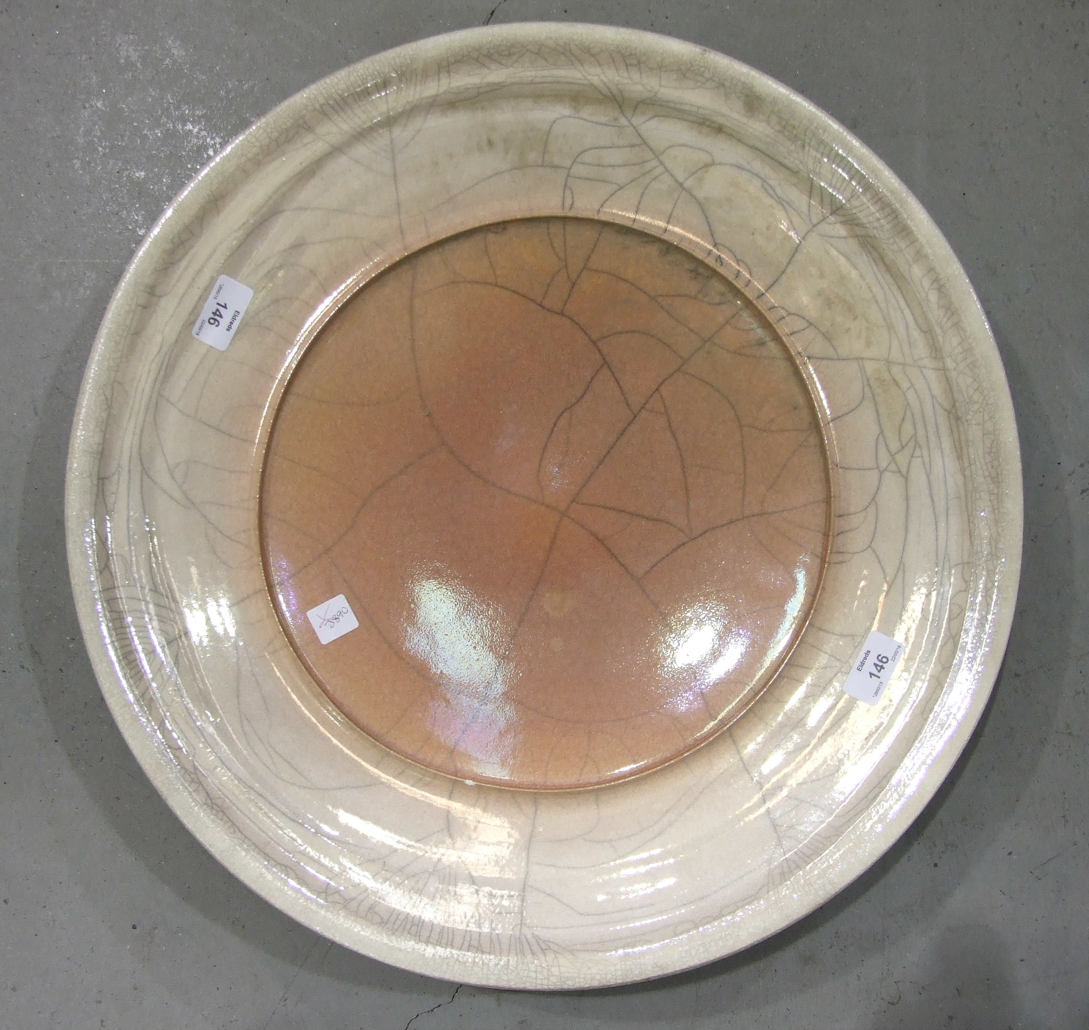 A modern 'Raku' charger by John Dunn in pale pink crackle glaze, 52cm diameter, with gilt-painted
