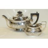 A George III silver half-gadrooned teapot by Robert and Samuel Hennell with wood handle and