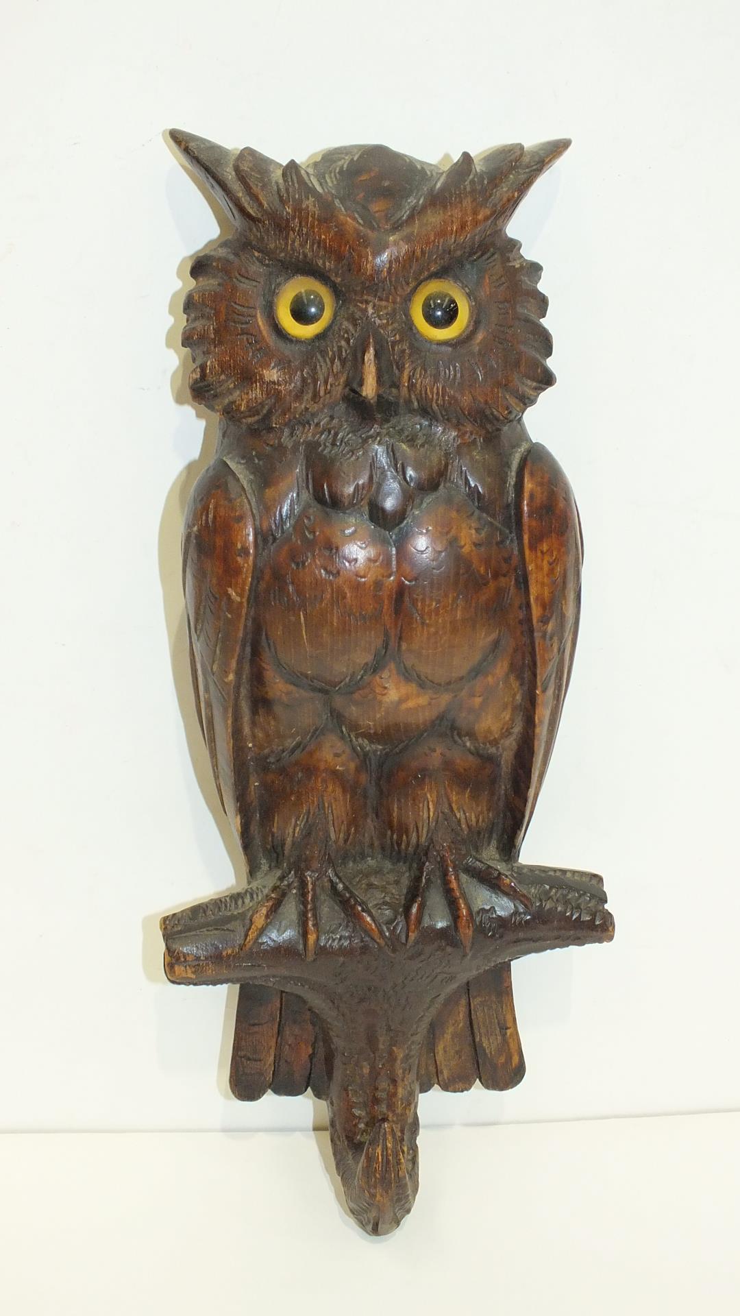 A 'Black Forest' carved wood coat peg in the form of an owl, 31cm high.