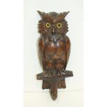 A 'Black Forest' carved wood coat peg in the form of an owl, 31cm high.