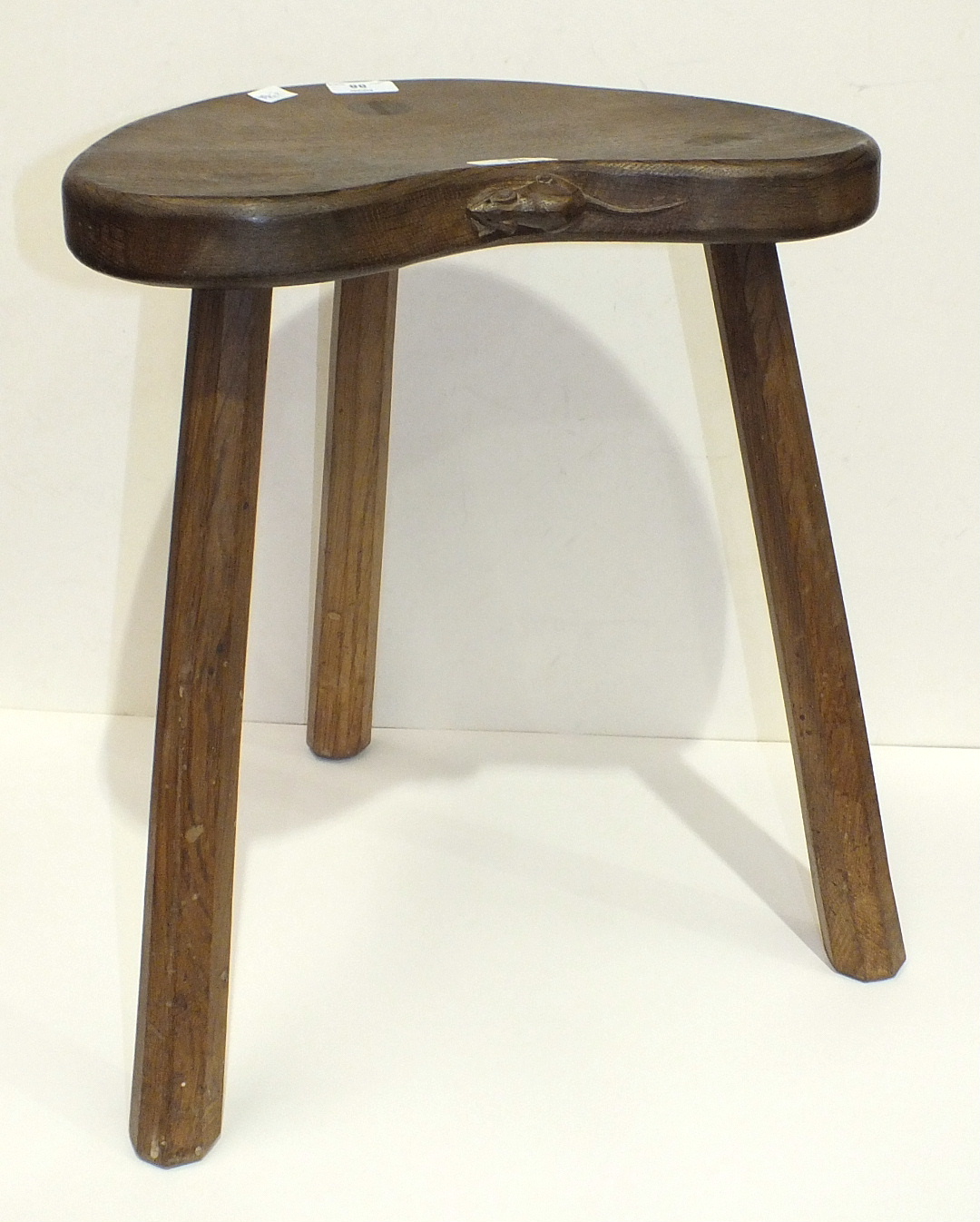 A Robert 'Mouseman' Thompson of Kilburn oak stool with dished kidney-shaped seat, raised on three