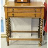 A 12-setting canteen of plated cutlery contained in an oak two-drawer table, on barley-twist