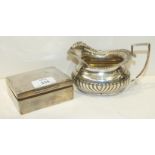 A silver half-gadrooned cream jug, 9cm high, Chester 1912, ___5oz and a silver cigarette box, 10 x