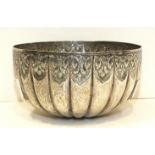 A circular white metal bowl of ribbed form, having embossed decoration, 10.7cm diameter, 5.5cm